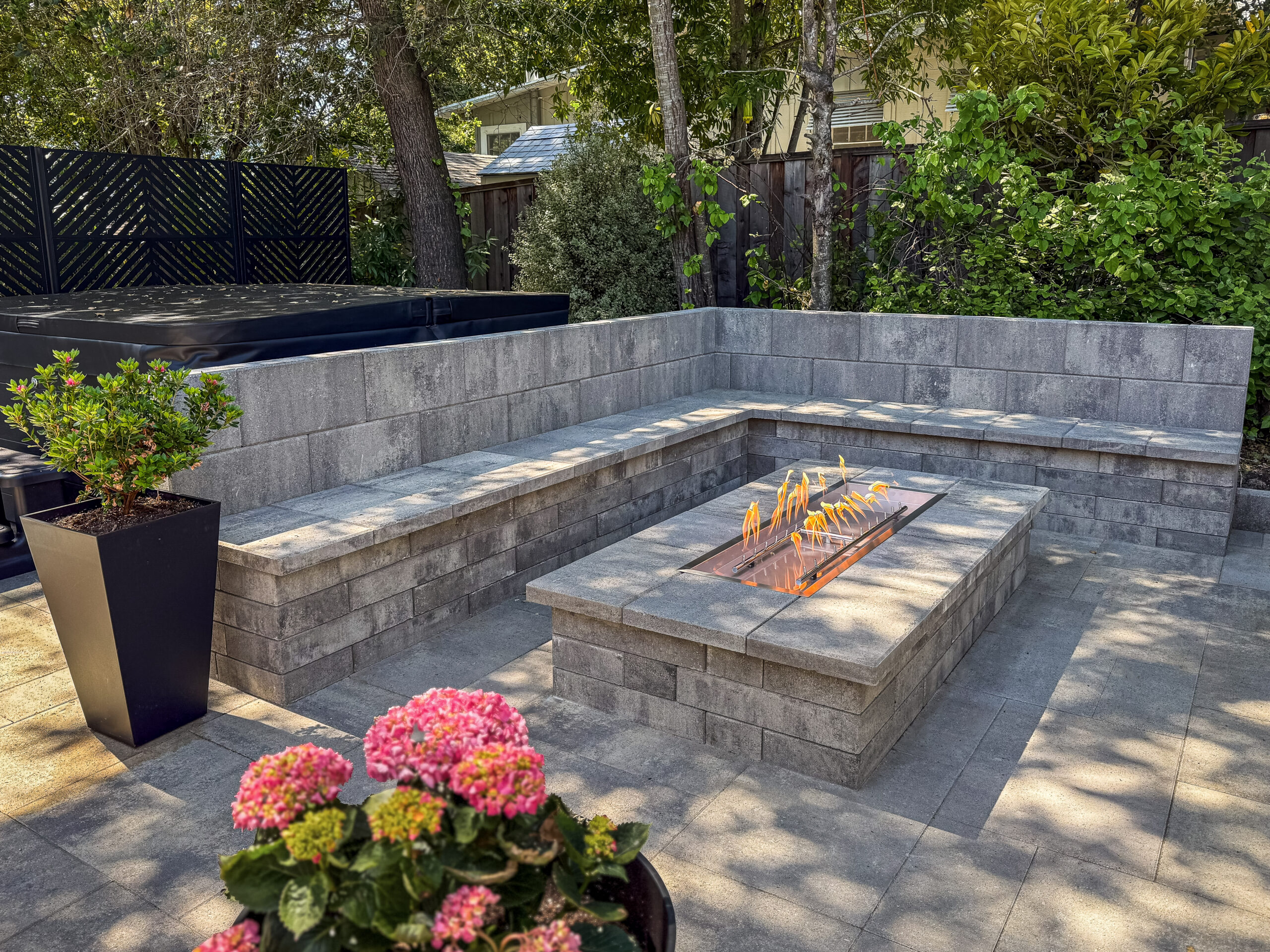 Custom fire pit with built-in seating wall on a paver patio