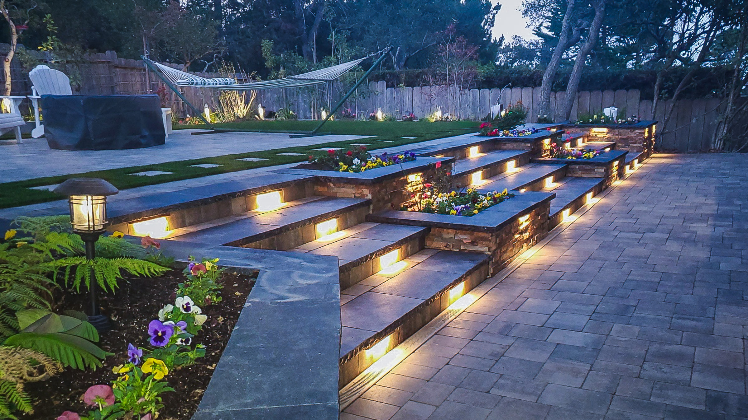 Outdoor step lighting illuminating stone steps and landscaped patio areas